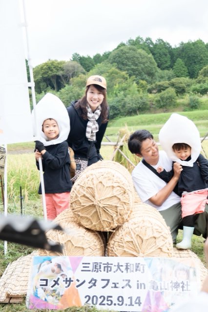田んぼで記念撮影をする親子