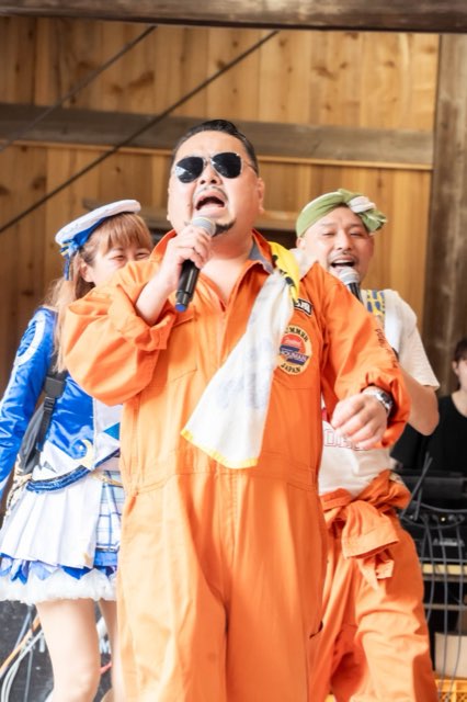 つなぎ姿でマイクを握るパフォーマー